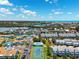 Panoramic aerial showcases waterfront condos with docks, along with a pool and tennis court, set in tropical landscape at 639 Garland Cir, Indian Rocks Beach, FL 33785