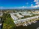 Wide aerial captures condo community with boat docks on canals, amid tropical greenery and views of the distant skyline at 639 Garland Cir, Indian Rocks Beach, FL 33785