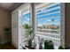 Balcony view framed by plantation shutters offers glimpse of waterfront and clear blue sky at 639 Garland Cir, Indian Rocks Beach, FL 33785