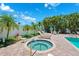 Relaxing hot tub and lounge area surrounded by lush tropical palms and a glimpse of the inviting community pool at 639 Garland Cir, Indian Rocks Beach, FL 33785