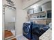 Laundry room featuring new blue front loading washer and dryer, mirror, and decorative storage at 639 Garland Cir, Indian Rocks Beach, FL 33785