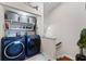 Laundry room features new blue front loading washer and dryer, plus decorative storage and shelving at 639 Garland Cir, Indian Rocks Beach, FL 33785