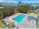 Aerial view of a community pool surrounded by lush landscaping, tables and sun loungers at 639 Garland Cir, Indian Rocks Beach, FL 33785
