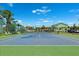 Well-maintained tennis court with green and blue surfaces, benches, and a glimpse of surrounding buildings at 639 Garland Cir, Indian Rocks Beach, FL 33785