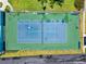 Aerial view of a tennis court showcasing its layout and surroundings, including green areas and nearby streets at 639 Garland Cir, Indian Rocks Beach, FL 33785