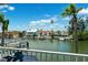 Scenic waterfront view from the balcony captures tranquil canal, swaying palms and charming residences at 639 Garland Cir, Indian Rocks Beach, FL 33785