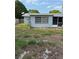 View of backyard with side of house and window; mostly patchy dirt with small amount of grass at 7222 Coventry Dr, Port Richey, FL 34668