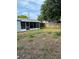View of backyard with screened in porch; mostly patchy dirt with small amount of grass at 7222 Coventry Dr, Port Richey, FL 34668