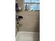 Clean bathroom with shower caddy, tiled walls, and a window showing outdoors at 7222 Coventry Dr, Port Richey, FL 34668