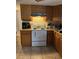 Functional kitchen featuring wood cabinets and a white range at 7222 Coventry Dr, Port Richey, FL 34668