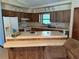 Functional kitchen featuring wooden cabinetry, essential appliances, and a convenient breakfast bar at 7239 Lykes Dublin Rd, Brooksville, FL 34601