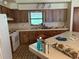 Functional kitchen featuring wooden cabinetry, essential appliances, and a convenient breakfast bar at 7239 Lykes Dublin Rd, Brooksville, FL 34601