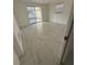 Light-filled bedroom with white walls, tile flooring, and a sliding glass door to the lanai at 7540 Briarwood Dr, Port Richey, FL 34668