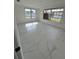 Bright bedroom featuring white walls, tile flooring, and natural light from large windows at 7540 Briarwood Dr, Port Richey, FL 34668