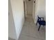 Hallway featuring white walls, white tile flooring and access to other rooms in the home at 7540 Briarwood Dr, Port Richey, FL 34668