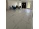 Spacious living room featuring bright white tile floors and abundant natural light from the double door entryway at 7540 Briarwood Dr, Port Richey, FL 34668