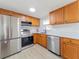 Well-equipped kitchen featuring stainless steel appliances, light countertops, and wood cabinets at 7608 Bougenville Dr, Port Richey, FL 34668