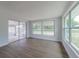 Bright living room featuring wood floors, sliding glass doors, and large windows at 7608 Bougenville Dr, Port Richey, FL 34668