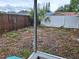 This backyard has a grass and leaves on the ground. The yard is enclosed with wood and vinyl fences at 7631 Briarwood Dr, Port Richey, FL 34668