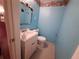 Small blue bathroom with toilet, sink and an aquarium themed decor at 7631 Briarwood Dr, Port Richey, FL 34668