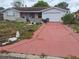 Exterior view of a one-story home with a long driveway and attached garage at 7631 Briarwood Dr, Port Richey, FL 34668