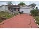 Single-Gathering home with a one car garage and a red driveway at 7631 Briarwood Dr, Port Richey, FL 34668