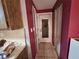 Hallway featuring a white door with window, closet, and red walls at 7631 Briarwood Dr, Port Richey, FL 34668