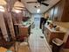 Galley kitchen, lots of items on the counters, and tile floors at 7631 Briarwood Dr, Port Richey, FL 34668