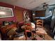 View of living room with a ceiling fan, desk and furniture, with red walls at 7631 Briarwood Dr, Port Richey, FL 34668