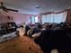 Spacious living room featuring floral furniture, and lots of items on the floor at 7631 Briarwood Dr, Port Richey, FL 34668