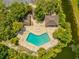Aerial view of kidney shaped community pool surrounded by greenery and waterfront scenery at 8158 Sturbridge Ct # D, Weeki Wachee, FL 34613