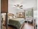 Bright bedroom with wood floors, a ceiling fan, a bed, dresser, and a comfortable seating area at 8158 Sturbridge Ct # D, Weeki Wachee, FL 34613