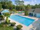 Outdoor pool area with lounge chairs and tables offering relaxation in this peaceful, beautiful community at 8158 Sturbridge Ct # D, Weeki Wachee, FL 34613