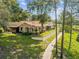 Exterior view of home surrounded by mature trees, green lawn, and landscaping at 8158 Sturbridge Ct # D, Weeki Wachee, FL 34613