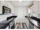 Updated kitchen with stainless steel appliances, black countertops and cream-colored cabinetry at 8158 Sturbridge Ct # D, Weeki Wachee, FL 34613