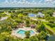 Aerial view of a community pool and surrounding amenities, set amongst lush landscaping and nearby pond at 8158 Sturbridge Ct # D, Weeki Wachee, FL 34613