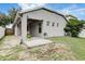 View of the home's backyard featuring a small patio and a well-maintained lawn at 8335 Crescent Moon Dr, New Port Richey, FL 34655
