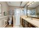 Bathroom with glass enclosed shower, neutral wall color, decorative mirror and wood cabinets at 8335 Crescent Moon Dr, New Port Richey, FL 34655