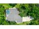 Aerial view of home's roof and pool surrounded by mature trees at 8518 Quail Hollow Blvd, Wesley Chapel, FL 33544