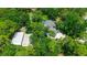 An aerial perspective highlights the backyard pool, home, detached garage, and ample surrounding trees at 8518 Quail Hollow Blvd, Wesley Chapel, FL 33544