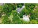 Aerial view of home nestled among lush trees, featuring a pool and adjacent outbuilding at 8518 Quail Hollow Blvd, Wesley Chapel, FL 33544