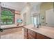 Elegant bathroom with stone accents and soaking tub under window, as well as vanity with sink at 8518 Quail Hollow Blvd, Wesley Chapel, FL 33544
