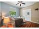 Bedroom features wood flooring, a ceiling fan, and a sunny window at 8518 Quail Hollow Blvd, Wesley Chapel, FL 33544