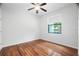 Bright bedroom features wood floors, ceiling fan, and natural light from the window at 8518 Quail Hollow Blvd, Wesley Chapel, FL 33544