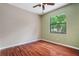 A bright bedroom with wood floors and a view of the outdoors at 8518 Quail Hollow Blvd, Wesley Chapel, FL 33544