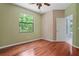 A large, bright bedroom with hardwood floors and a window that faces lush greenery at 8518 Quail Hollow Blvd, Wesley Chapel, FL 33544