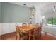 A dining room with chair rail accents, hardwood flooring and views into the living room and back yard at 8518 Quail Hollow Blvd, Wesley Chapel, FL 33544