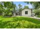 View of the home with a screened in lanai and luscious green grass in the front yard at 8518 Quail Hollow Blvd, Wesley Chapel, FL 33544