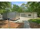Large metal garage with dual doors, adjacent to a wide driveway and featuring mature trees at 8518 Quail Hollow Blvd, Wesley Chapel, FL 33544