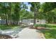 View of large metal garage with a trailer parked outside amidst lush greenery, offering ample outdoor space at 8518 Quail Hollow Blvd, Wesley Chapel, FL 33544